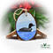 A hand-painted common loon on blue water with a blue sky hand-painted on a wood slice at Cove Creek Photography.